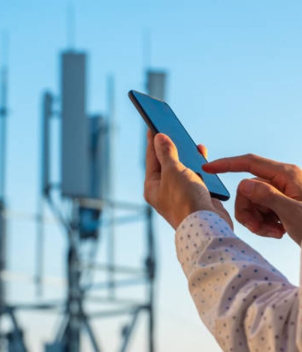 5G communications tower with man using mobile phone